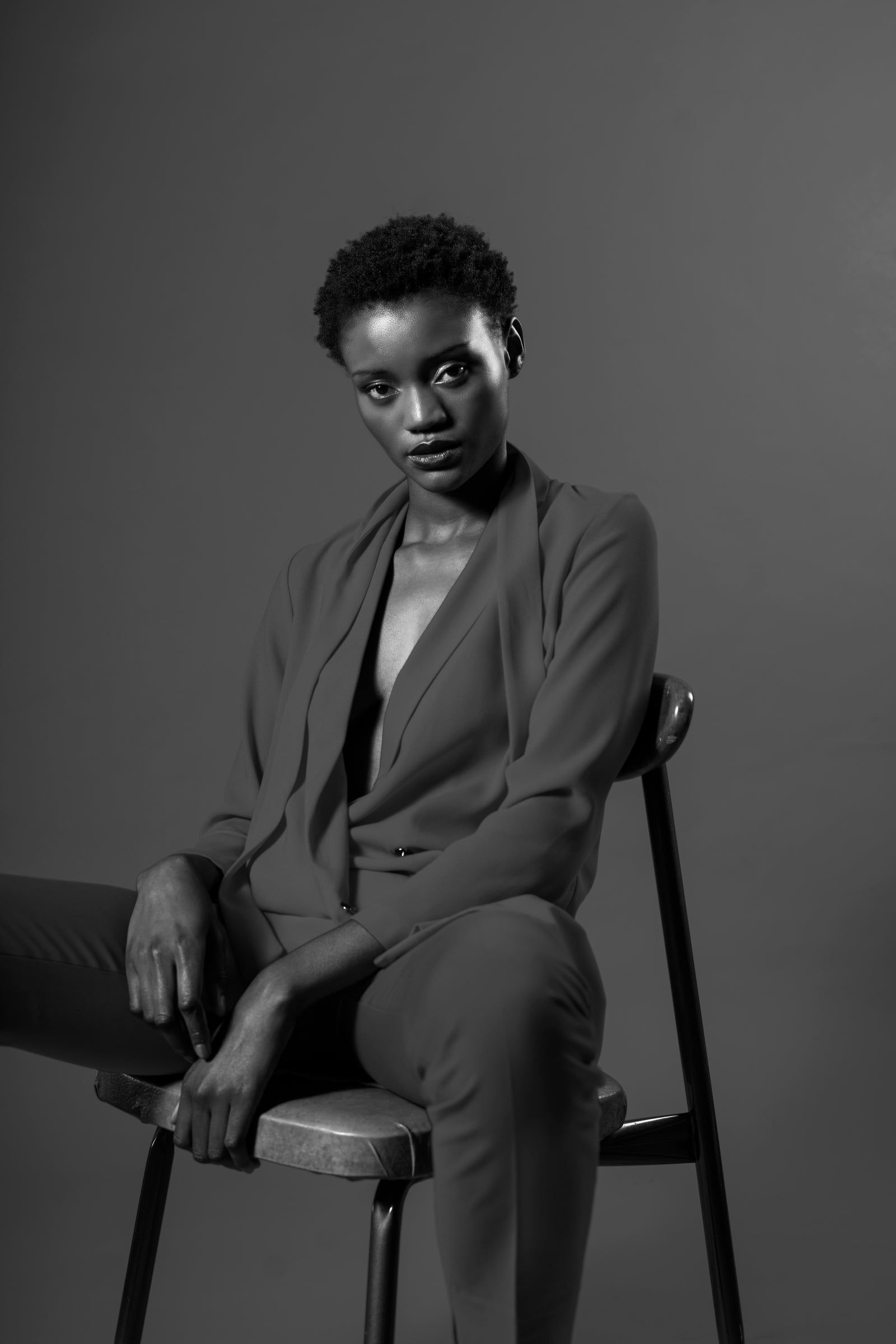 Femme en tailleur sombre assise, photo noir et blanc